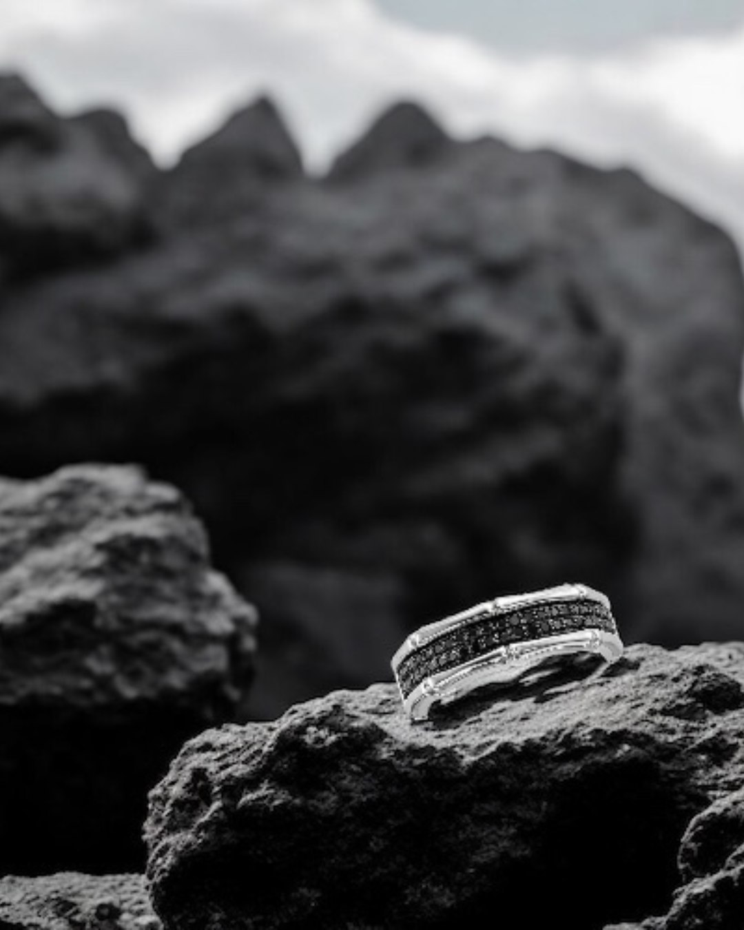 Polished sterling silver men's ring with bone shaped details and two rows of pavé set black diamonds