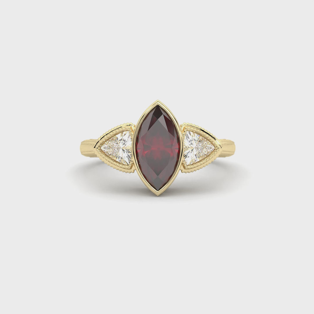 Hypnotic Ring in 14k yellow gold with marquise cut lab created ruby and trillion cut lab created diamonds, bezel set with milgrain detailing